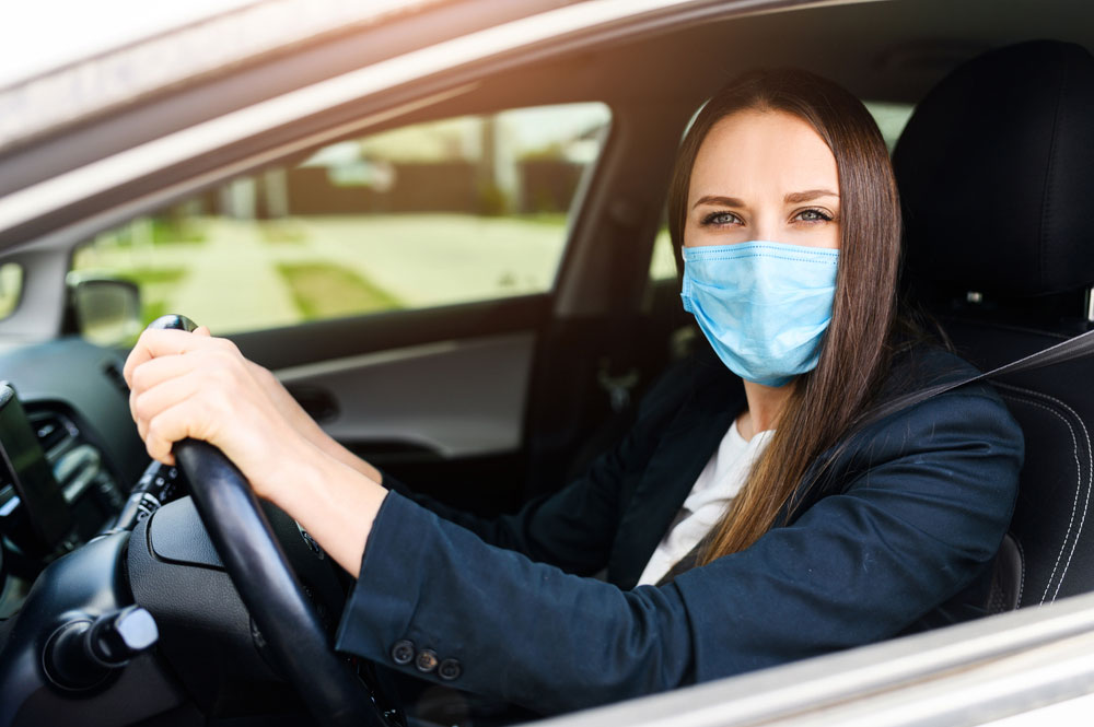 Mulher de máscara no carro