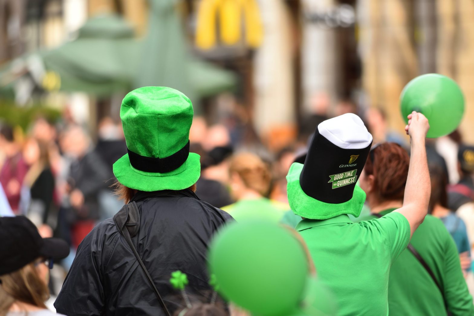 Público comemorando com chapéus e roupas verdes em um evento festivo, com destaque para a atmosfera alegre; ConectCar presente na celebração.